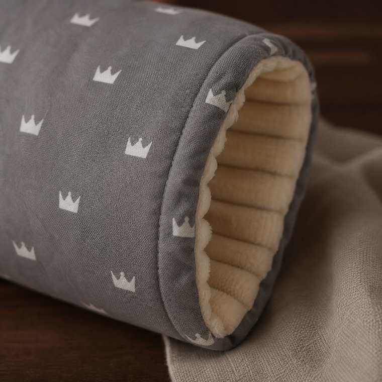 Gros plan sur le tissu à couronnes et l’intérieur rembourré du coussin de bras.