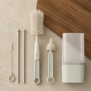 Brosses pour biberons et accessoires disposées à côté de leur boîtier de rangement.