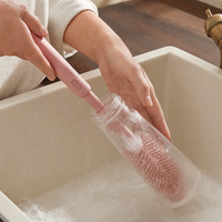 Nettoyage de l’intérieur d’un biberon avec la grande brosse rose.